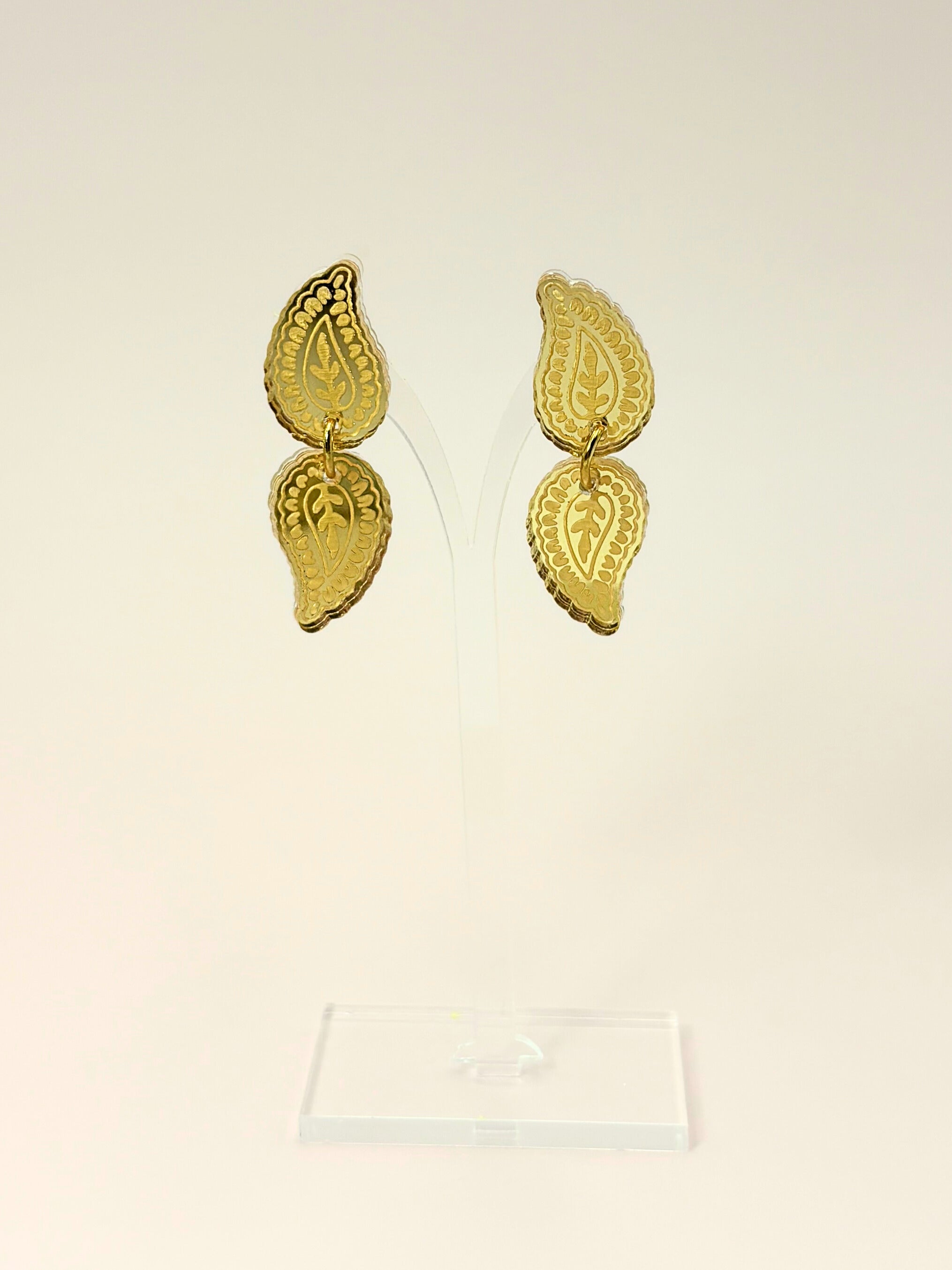 Pair of gold earrings on a beige background