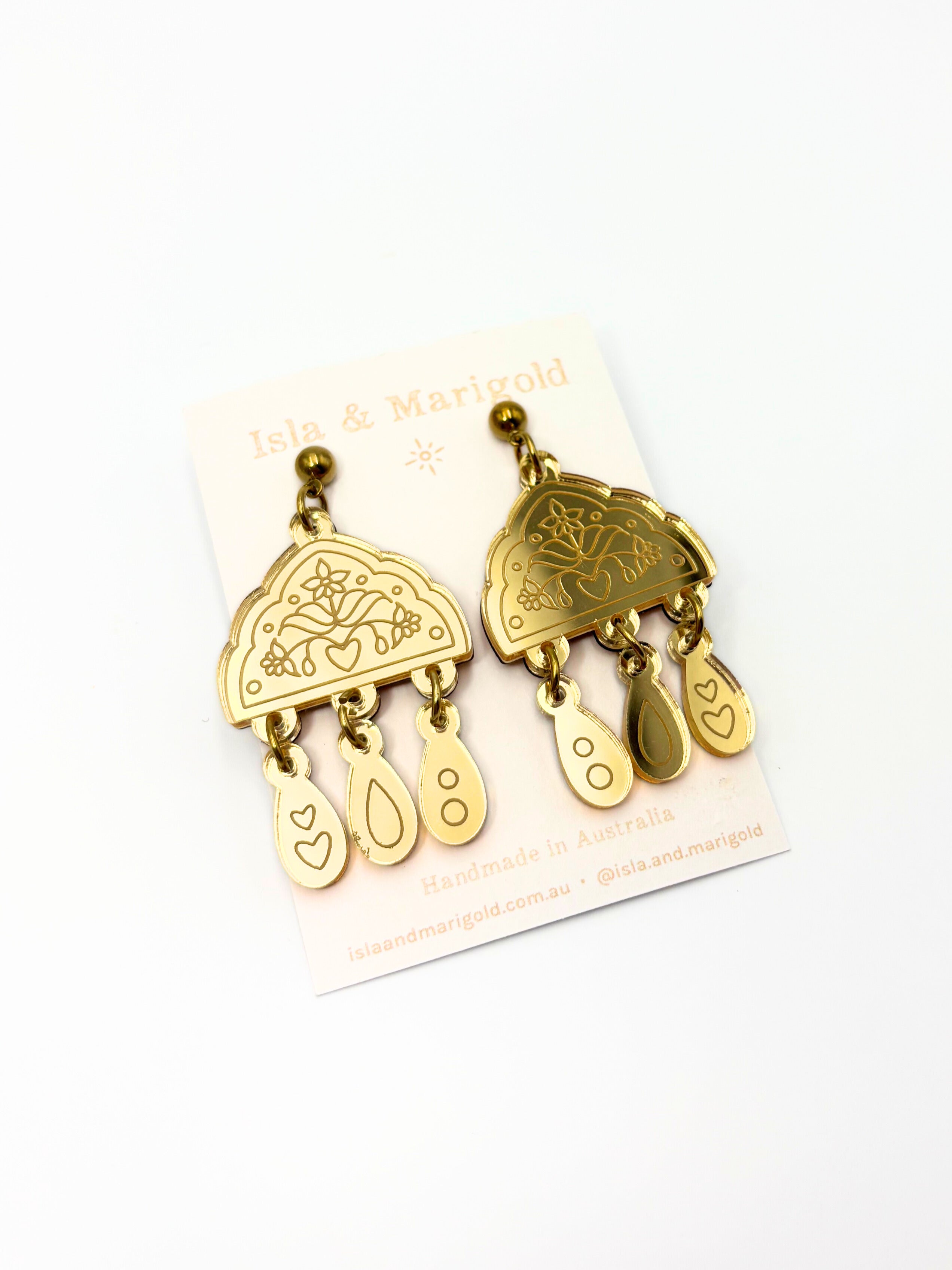 Gold earrings on a white card with 'Isla & Marigold' branding.