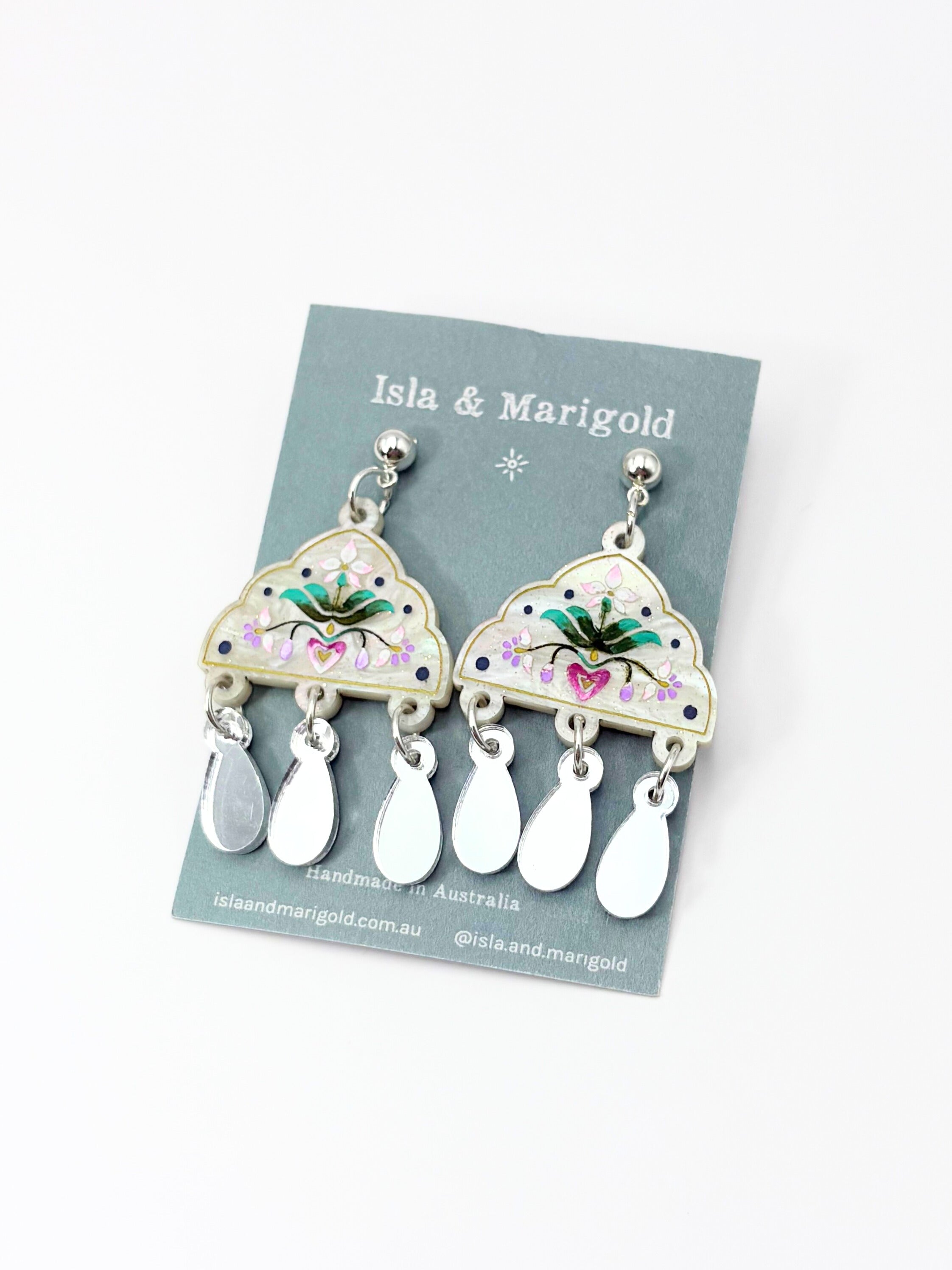 Pair of earrings on a 'Isla & Marigold' branded card with floral design.