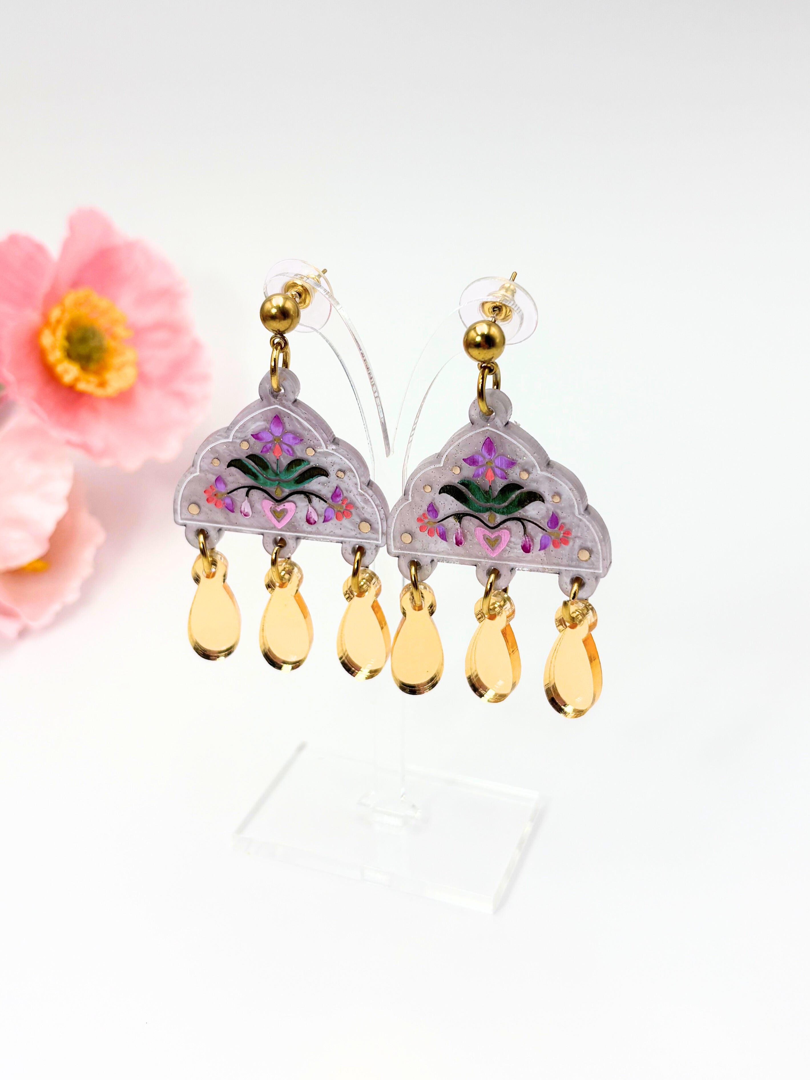Decorative acrylic Indian style earrings with floral design and gold accents on a white background