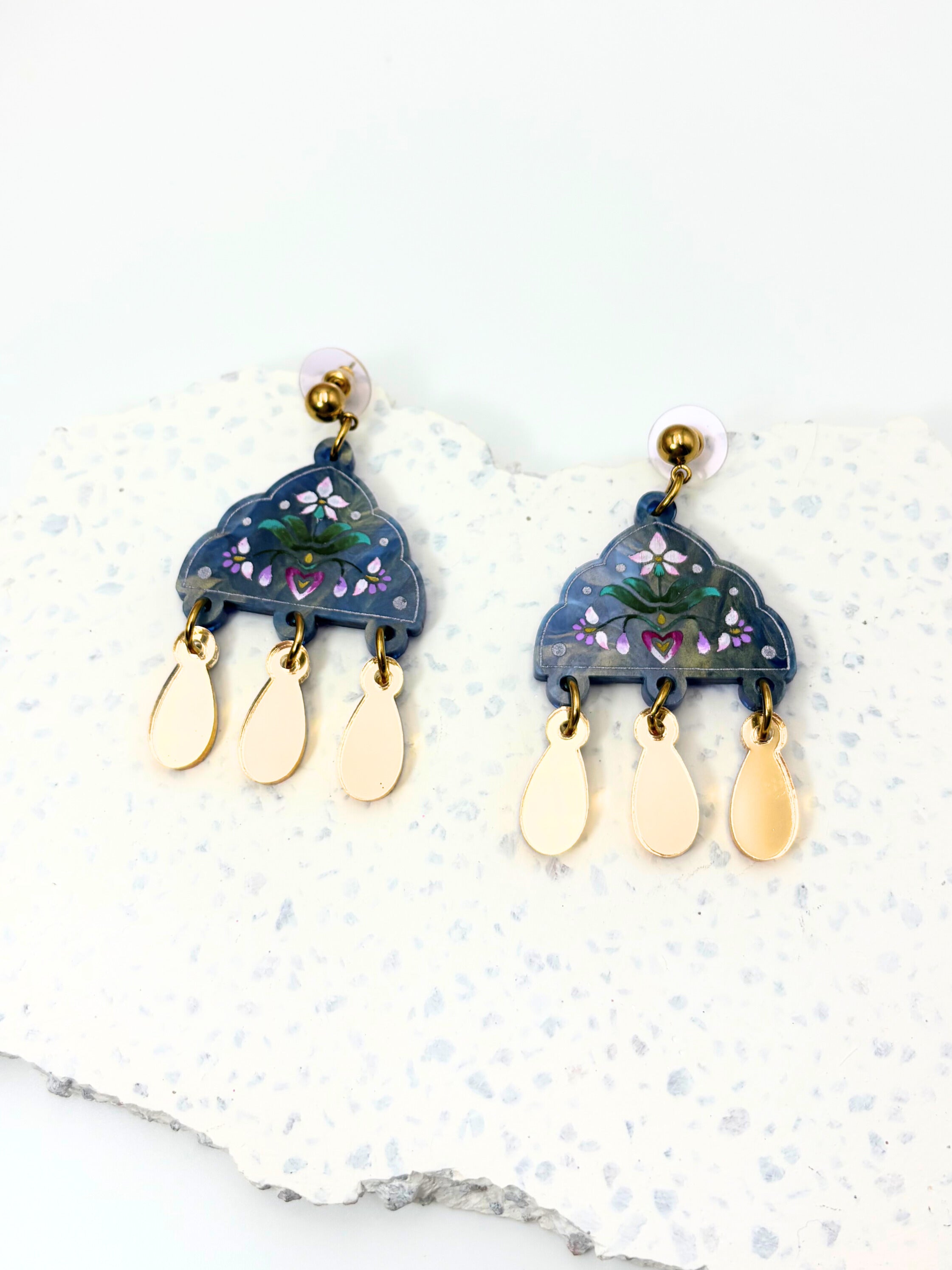 Pair of earrings with blue and gold design on a white background