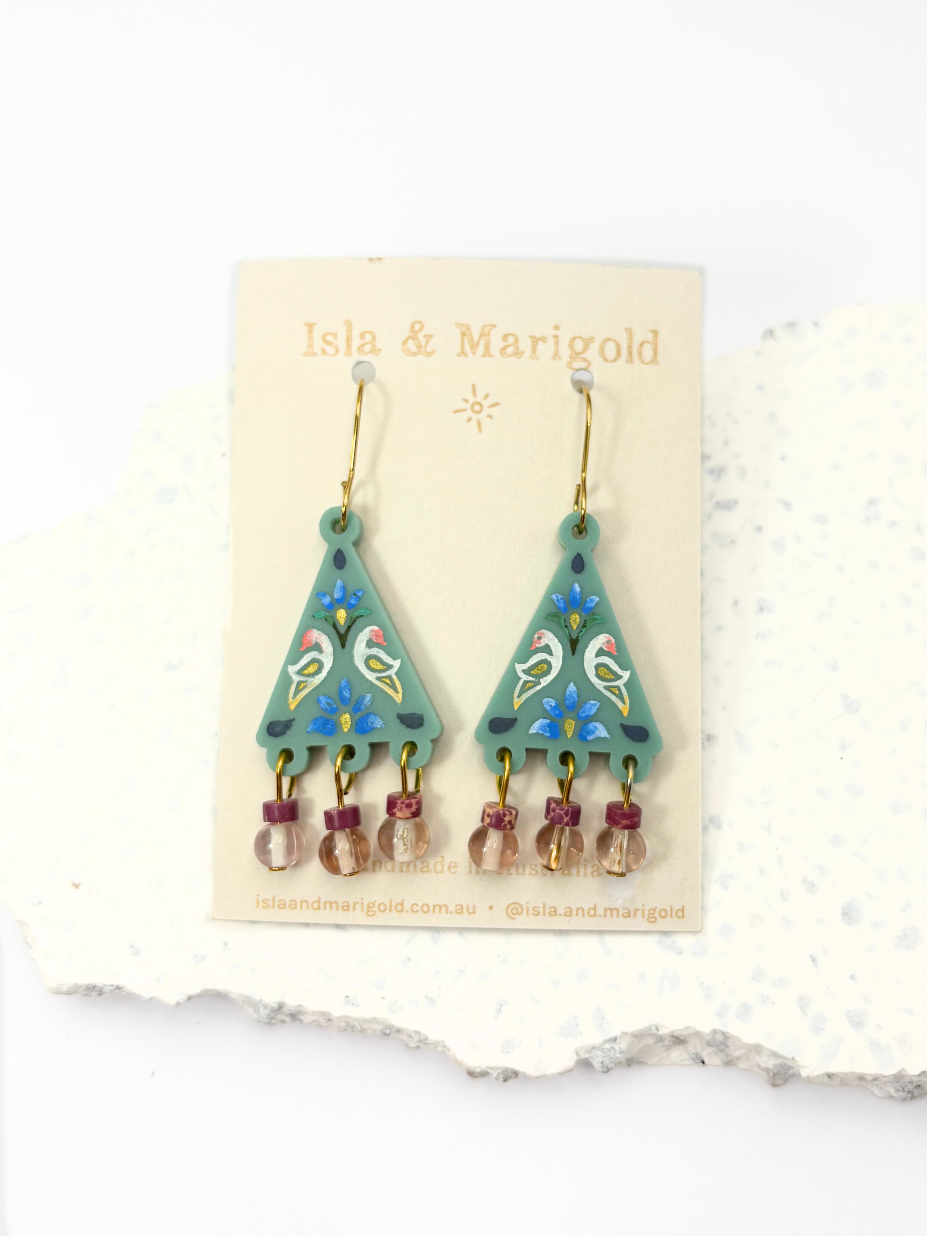 Pair of earrings on a 'Isla & Marigold' branded card against a white background