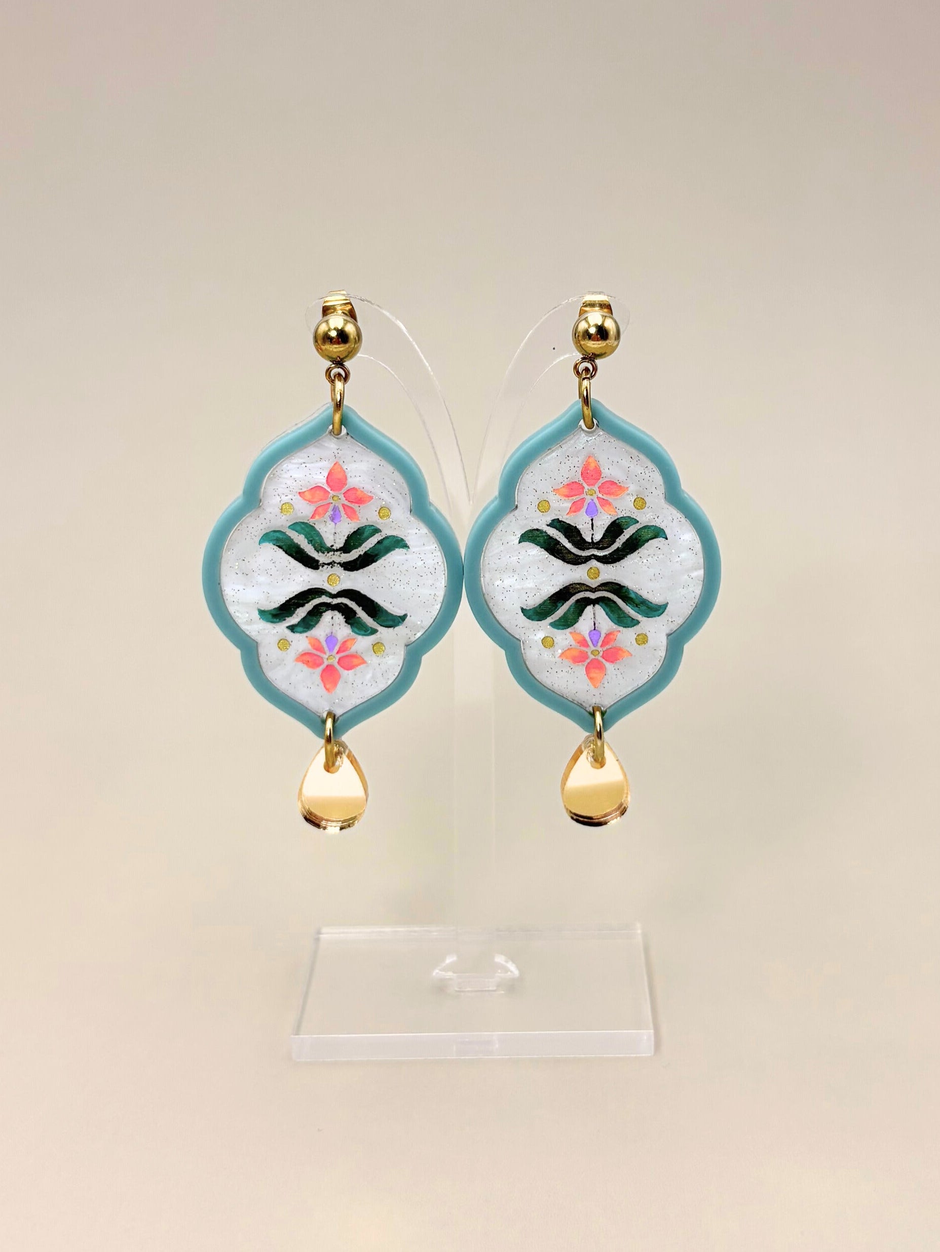 Pair of earrings with floral design on a beige background