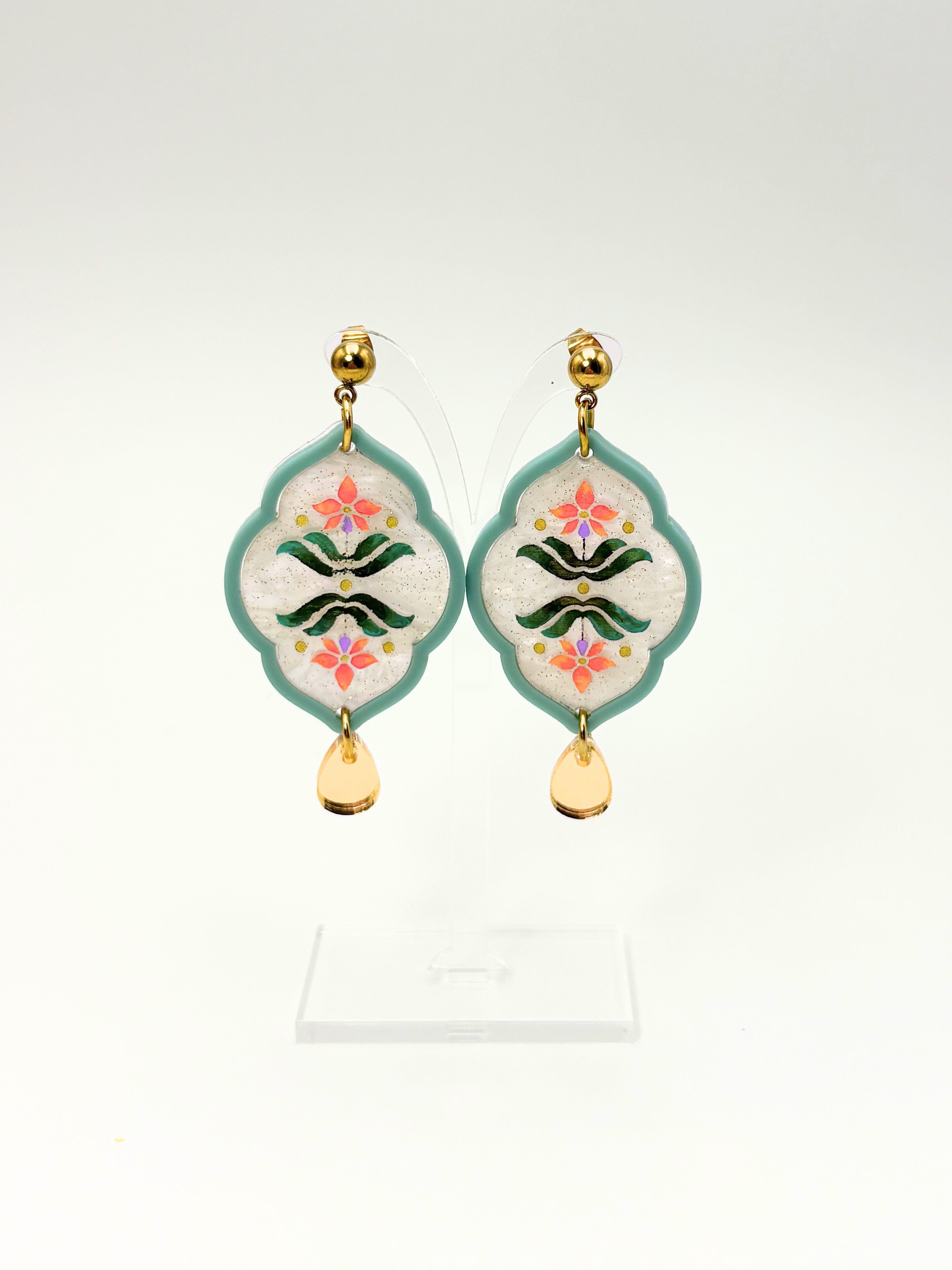 Decorative earrings with floral patterns on a white background