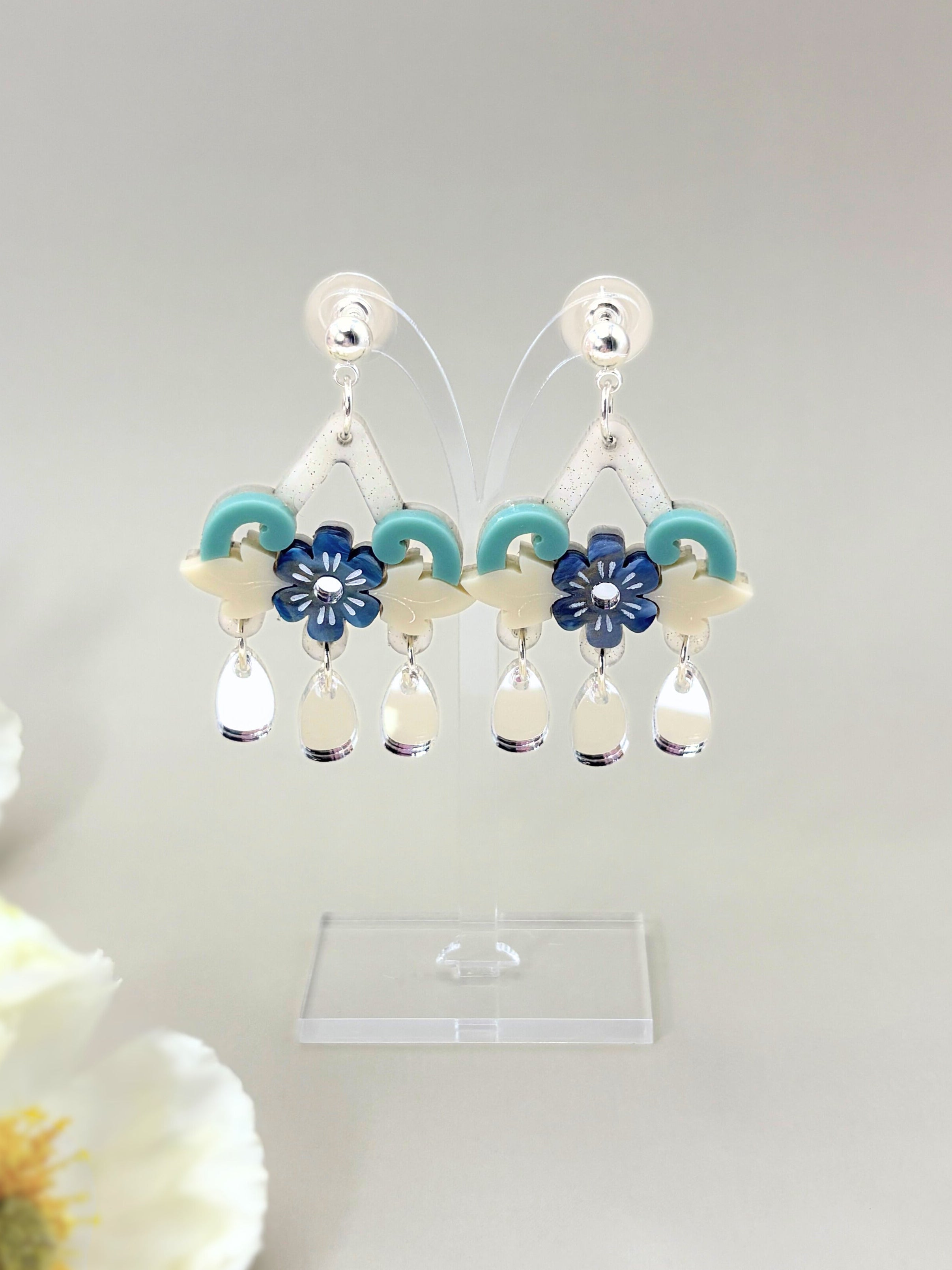 Pair of earrings with floral designs on a white background