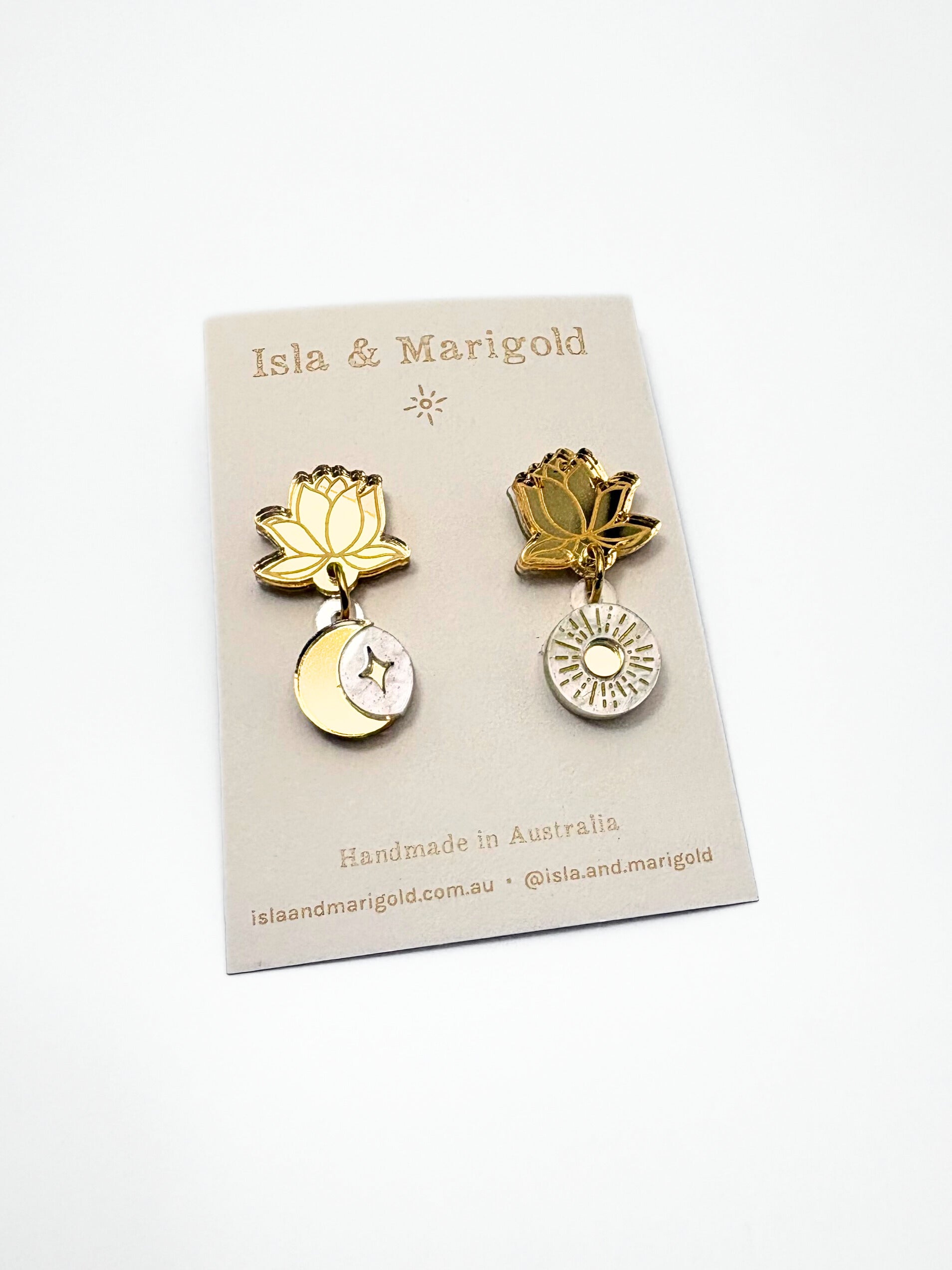 Gold lotus flower earrings on a branded card with 'Isla & Marigold' branding.