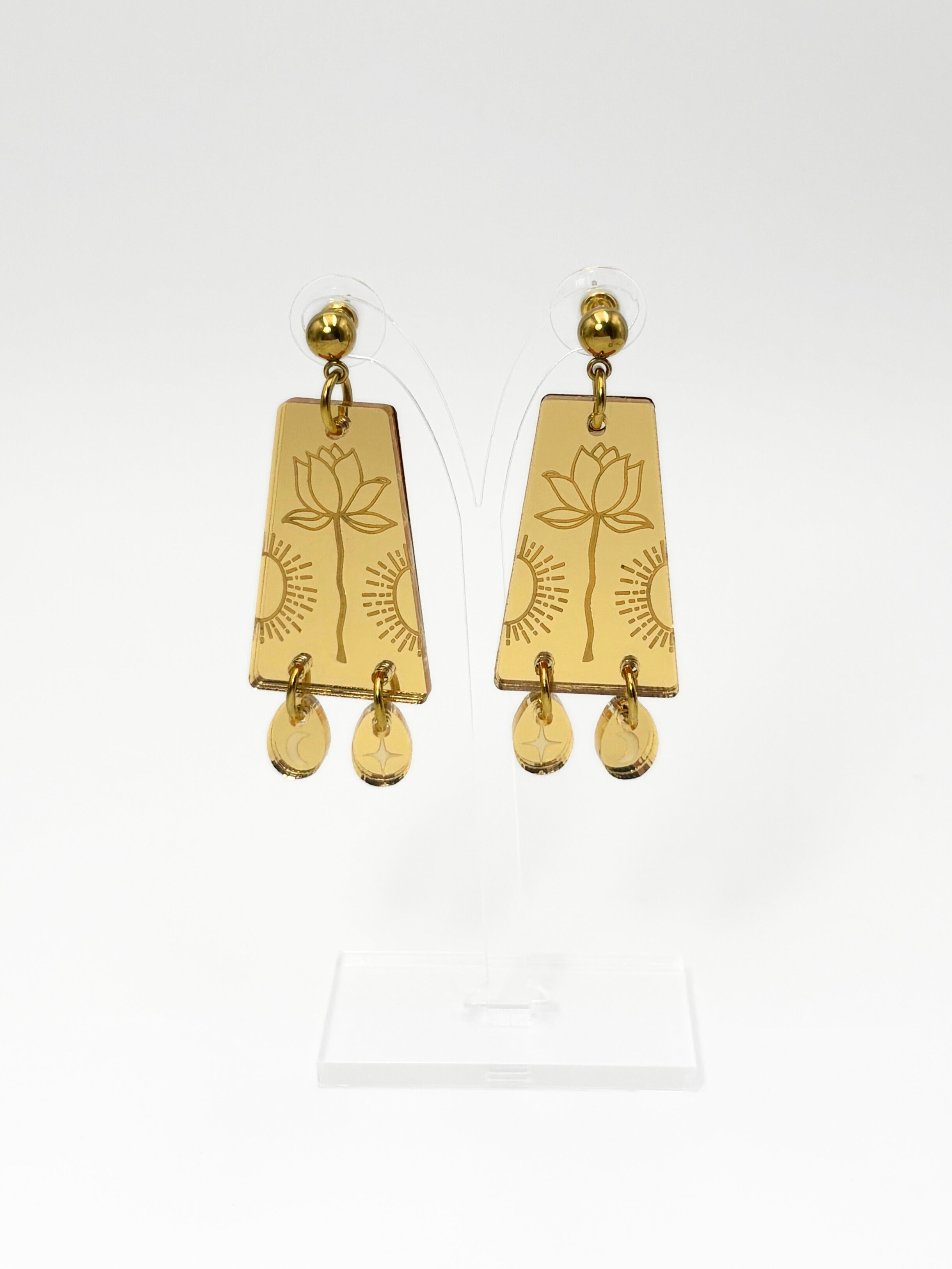 Gold earrings with floral design on a white background