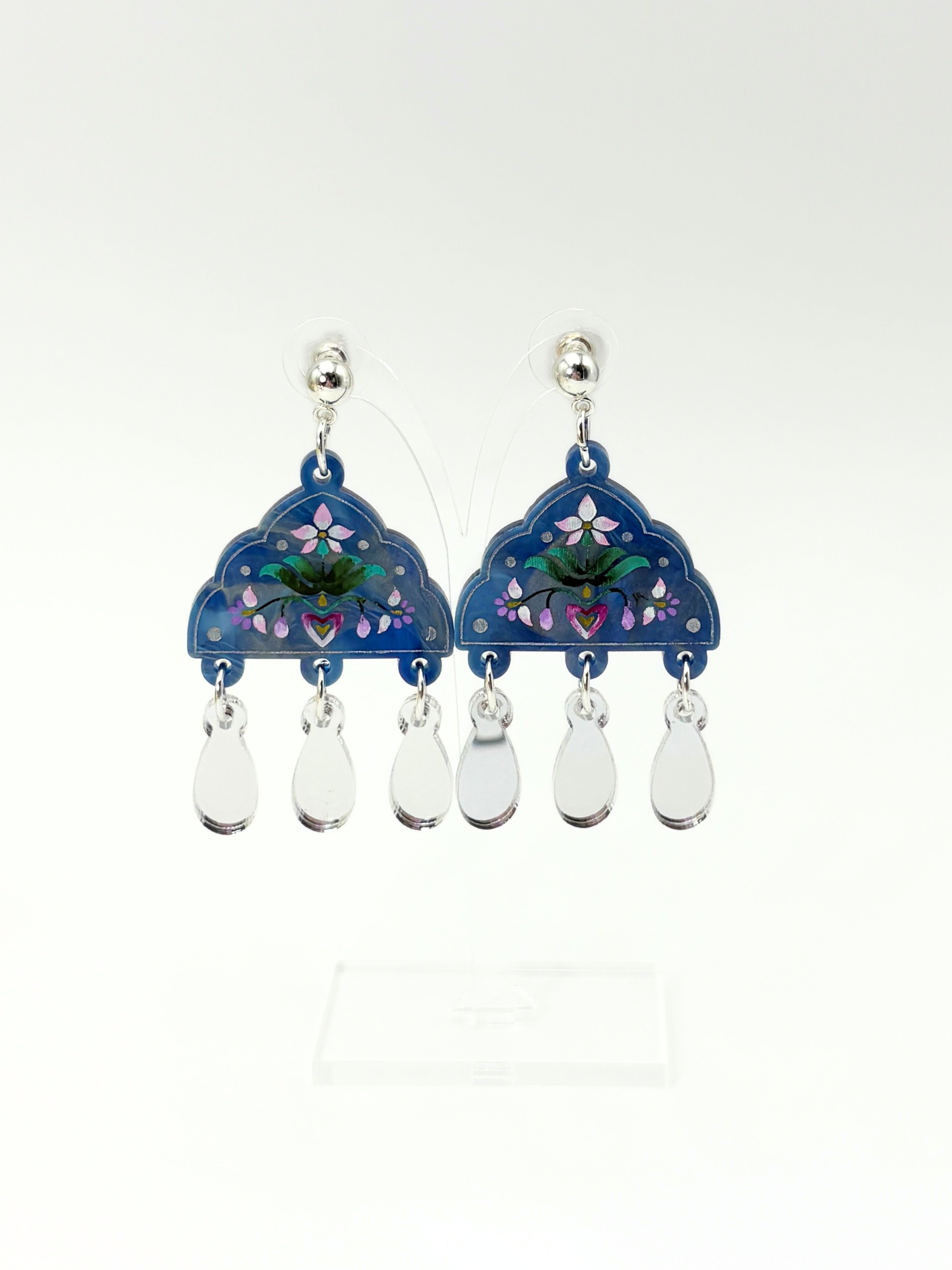 Pair of acrylic earrings with floral design and teardrop-shaped elements on a white background