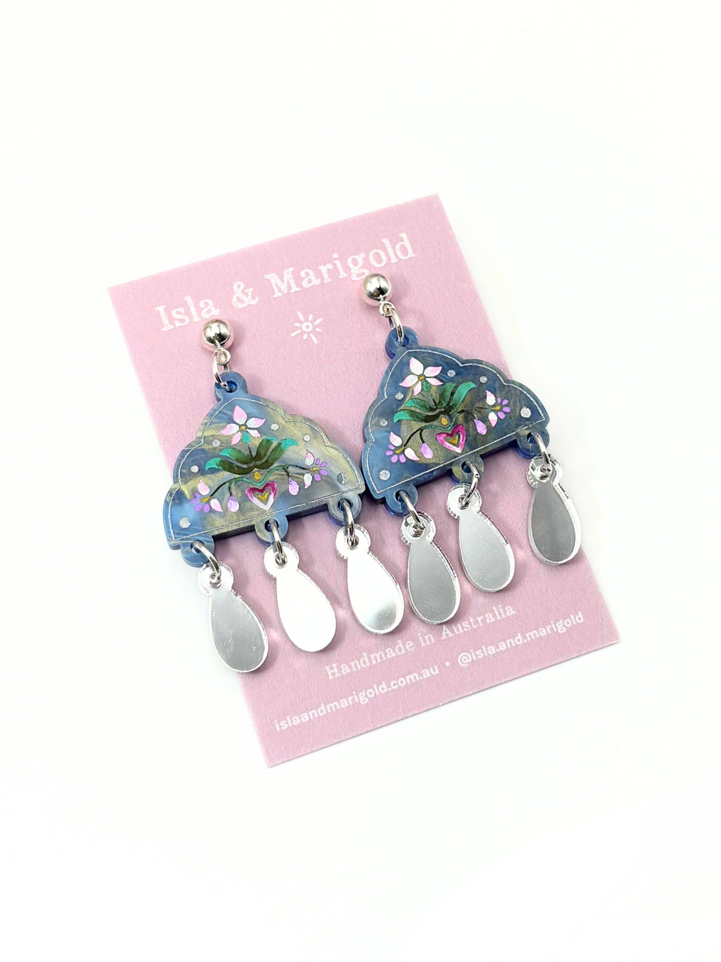 Pair of earrings on a pink card with 'Isla & Marigold' branding.