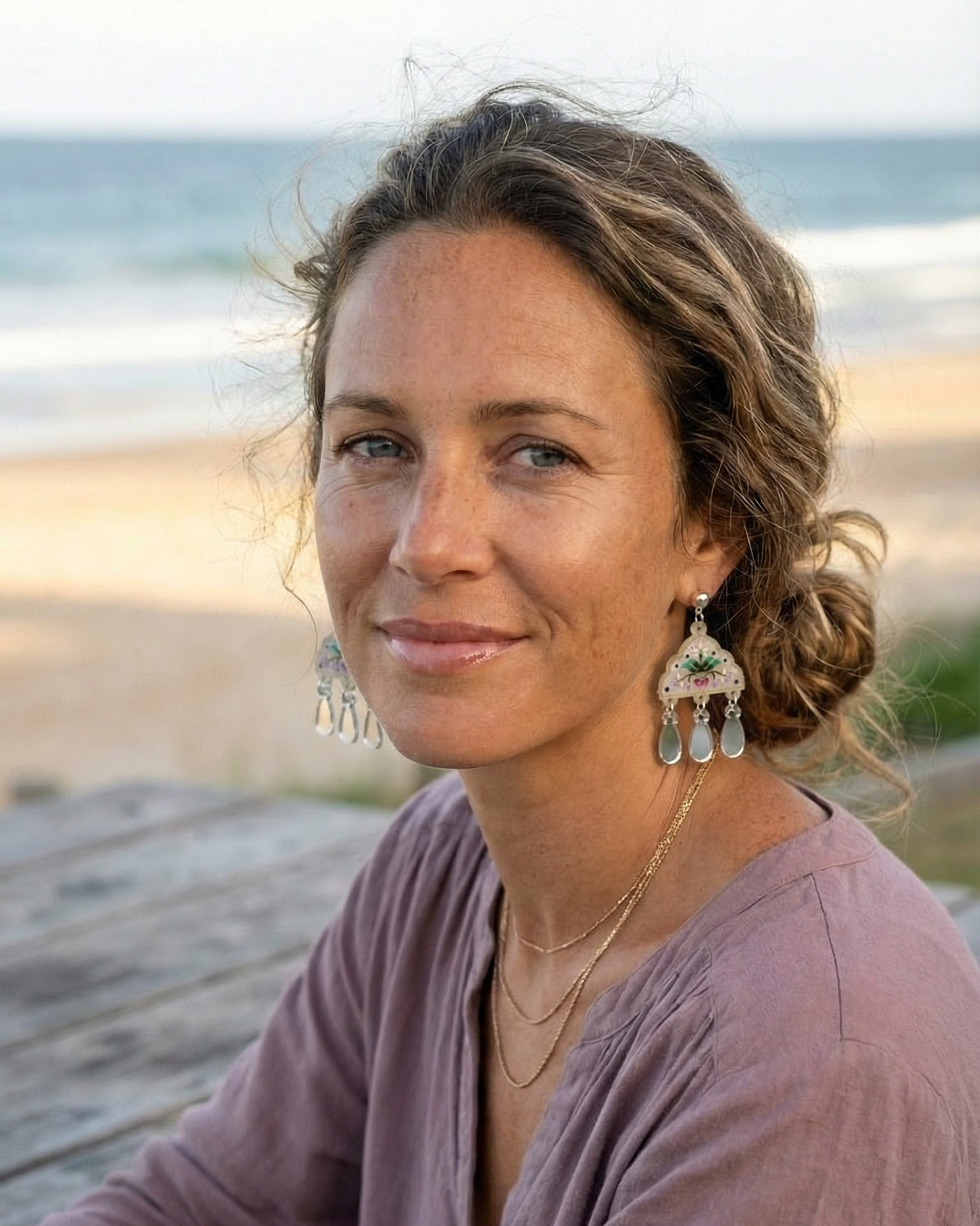 Woman sitting on a wooden bench by the beach with ocean view