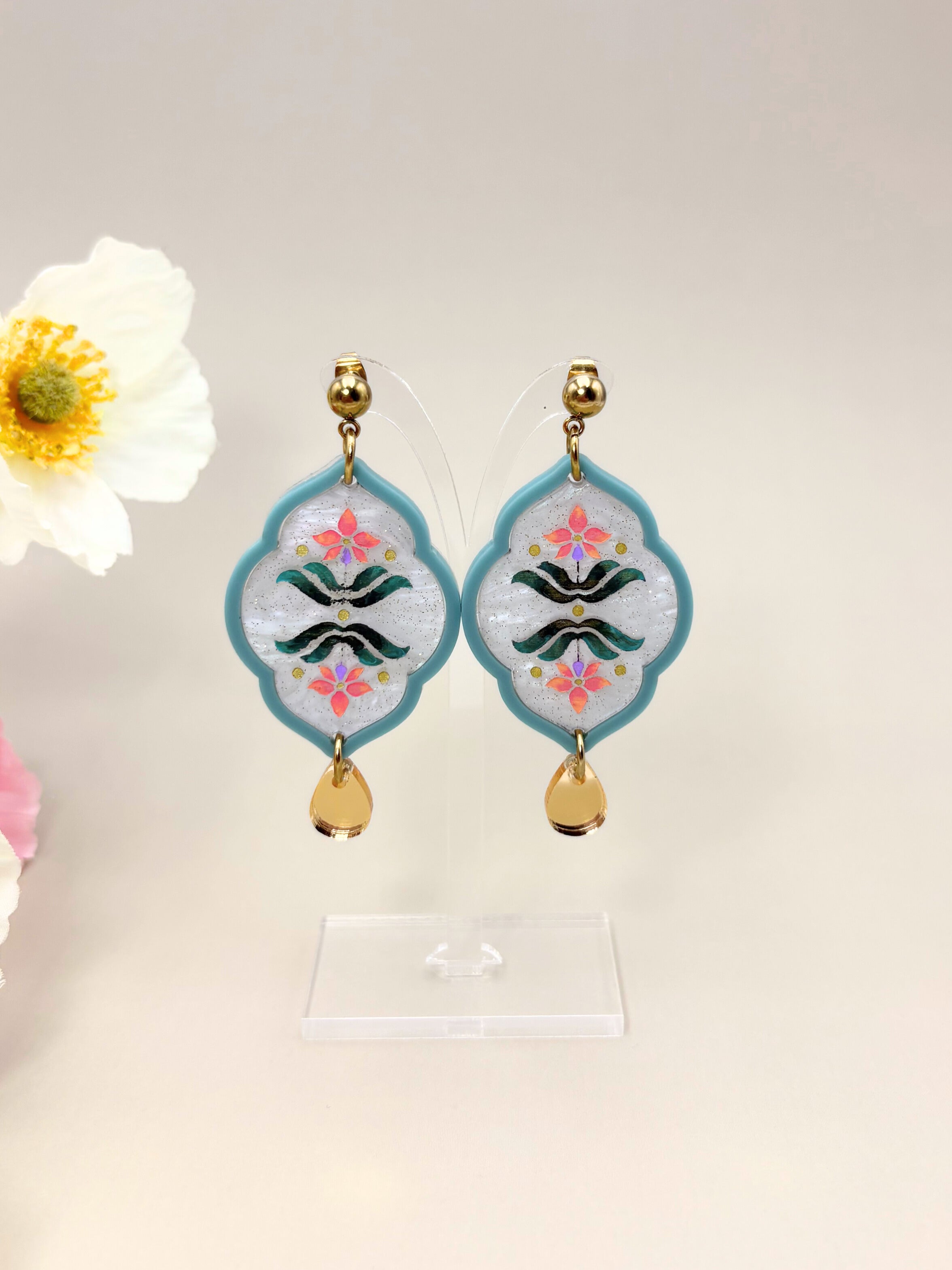 Decorative earrings with floral design on a light background