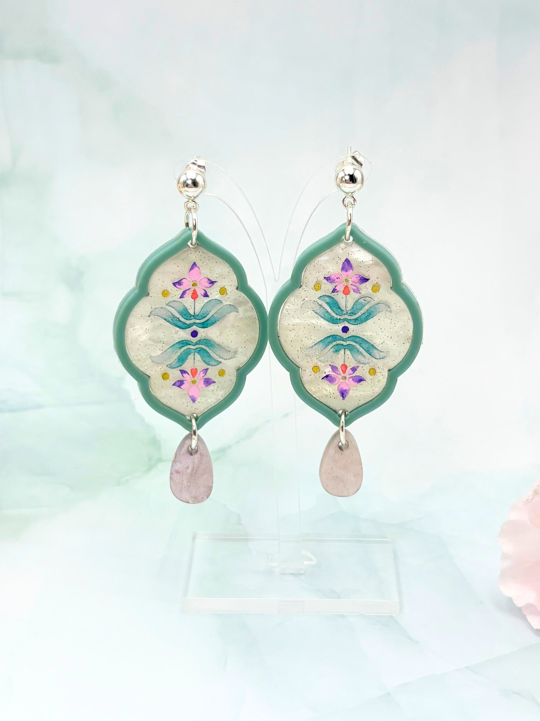 Decorative earrings with floral designs on a light background