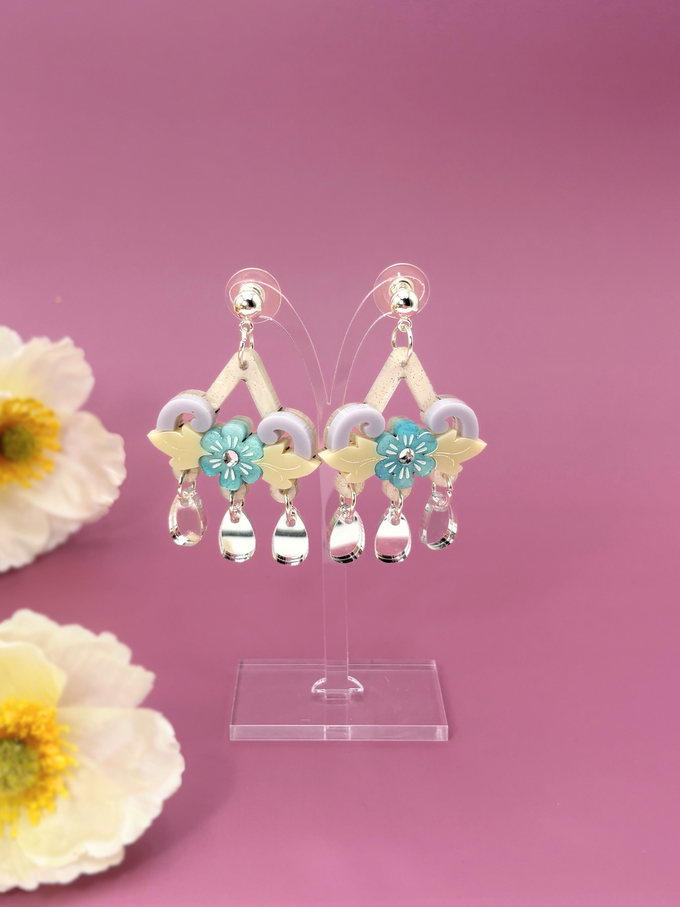 Acrylic  earrings with floral designs on a pink background