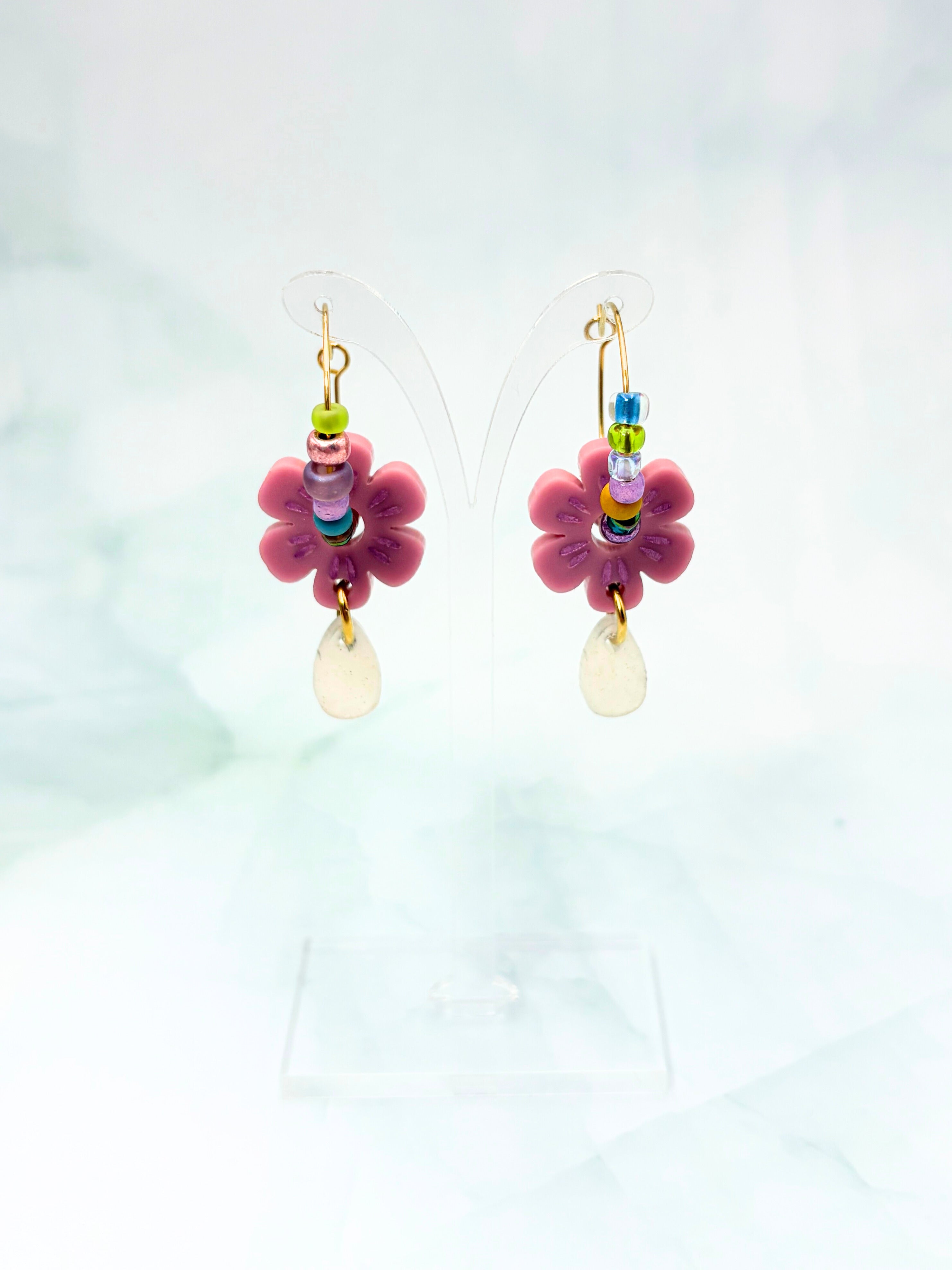 Pair of colorful flower-shaped earrings on a light background