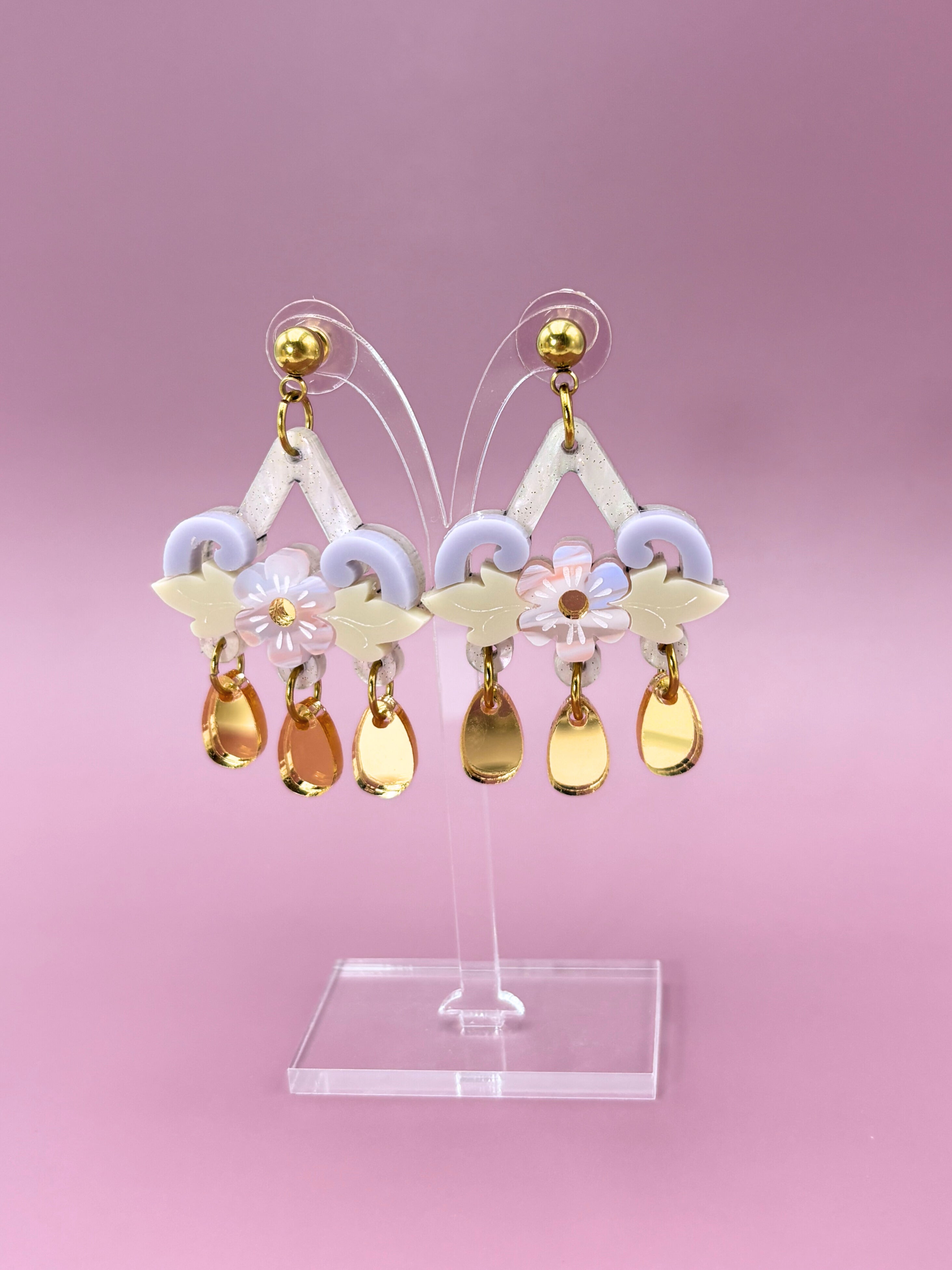 Earrings with colorful drops on a pink background